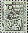 Boy and girl with the book Ã¢â¬ÅWeltall, Erde, MenschÃ¢â¬Â, symbolic Royalty Free Stock Photo